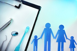A clipboard with dental instruments and a pen and a family cut-out in Shorewood