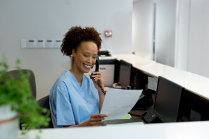 a front desk medical staff speaking on the phone