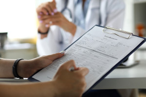 a patient filling out forms on a clipboard