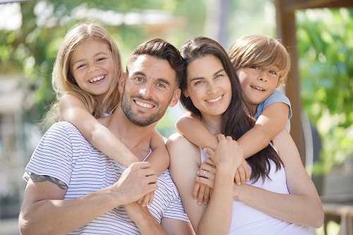 Family of four sharing their healthy smiles