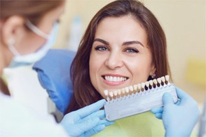 Shorewood cosmetic dentist checking shade of aptient's teeth