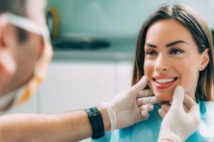 a woman smiling after getting a cosmetic dental treatment